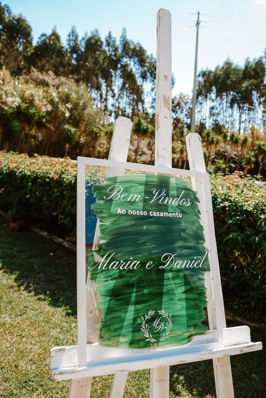 Placa de boas-vindas em acrílico num cavalete, ao ar livre