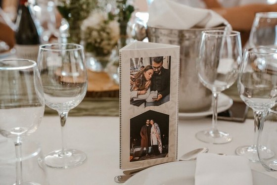 Marcador de mesa com fotografias dos noivos entre copos